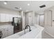 Modern kitchen featuring stainless steel appliances, ample white cabinetry, and a breakfast bar at 181 Padova Way, Nokomis, FL 34275
