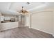 Open-concept living room featuring hardwood floors, a ceiling fan, and an arched doorway at 181 Padova Way # 19, Nokomis, FL 34275