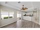 Open-concept living area featuring wood floors, modern fan, and sliding glass door to outdoor space at 181 Padova Way # 19, Nokomis, FL 34275