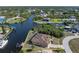 Aerial view of a waterfront home with a private dock, surrounded by lush greenery and canal access at 18602 Ashcroft Cir, Port Charlotte, FL 33948