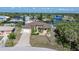Aerial view of a single Gathering home with a paver driveway, manicured lawn, and waterfront access at 18602 Ashcroft Cir, Port Charlotte, FL 33948