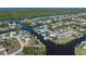 Aerial view of the waterfront property, showcasing canal access and lush landscaping in a vibrant coastal community at 18602 Ashcroft Cir, Port Charlotte, FL 33948