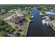 Waterfront home featuring a screened lanai, palm trees, and a private dock on a canal with boat lift at 18602 Ashcroft Cir, Port Charlotte, FL 33948