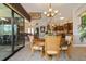 Formal dining area with an outdoor view, chandelier, and stylish drapery. Kitchen is visible in the background at 18602 Ashcroft Cir, Port Charlotte, FL 33948