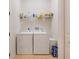 Bright laundry room area with washer, dryer, and storage shelves at 18602 Ashcroft Cir, Port Charlotte, FL 33948