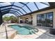 Screened-in pool area featuring a heated pool, and an outdoor kitchen and dining area at 18602 Ashcroft Cir, Port Charlotte, FL 33948