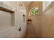 Shower with built in shelving and bench seat with a window above at 18602 Ashcroft Cir, Port Charlotte, FL 33948