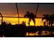 Beautiful water view showing a vivid yellow and orange sunset sky with silhouetted palm trees at 18602 Ashcroft Cir, Port Charlotte, FL 33948