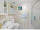 Clean bathroom featuring a sink, toilet, and walk-in shower with a glass door at 19505 Quesada Ave # M104, Port Charlotte, FL 33948