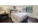 Comfortable bedroom with a queen bed, natural lighting, and wood laminate flooring at 19505 Quesada Ave # M104, Port Charlotte, FL 33948