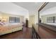 Spacious bedroom showcasing dark wood floors, dresser, and mirror with an outdoor view at 19505 Quesada Ave # M104, Port Charlotte, FL 33948
