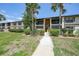 Condo exterior featuring well-maintained landscaping and a walkway to the building entrance at 19505 Quesada Ave # M104, Port Charlotte, FL 33948