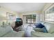 Bright living room with sliding glass doors to the patio and comfortable seating at 19505 Quesada Ave # M104, Port Charlotte, FL 33948