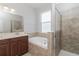A bathroom with double sinks, garden tub, tile surround, and glass enclosed shower at 20067 Oakflower Ave, Tampa, FL 33647