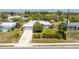 Aerial view of property showcasing well-manicured lawn and tropical landscaping surrounding a light-gray home at 2008 Pellam Blvd, Port Charlotte, FL 33948