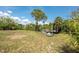 Spacious backyard with mature trees and lush landscaping offers plenty of room for outdoor activities and storage at 2008 Pellam Blvd, Port Charlotte, FL 33948