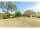 Expansive backyard with lush trees and vegetation, featuring a trailer and boat trailer at 2008 Pellam Blvd, Port Charlotte, FL 33948
