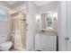 Well-lit bathroom featuring a vanity with a sink, a shower with decorative tile, and a toilet at 2008 Pellam Blvd, Port Charlotte, FL 33948