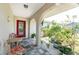 Inviting front porch featuring tiled flooring, seating, and vibrant plants at 2008 Pellam Blvd, Port Charlotte, FL 33948