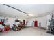 Organized garage space with ample storage, featuring a lawn mower and red refrigerator at 2008 Pellam Blvd, Port Charlotte, FL 33948