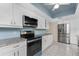 Updated kitchen featuring granite counters, stainless steel appliances, bright lighting, and ample cabinet space at 2008 Pellam Blvd, Port Charlotte, FL 33948