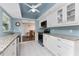 Updated kitchen with white cabinets, granite countertops, stainless steel appliances, and modern ceiling fan at 2008 Pellam Blvd, Port Charlotte, FL 33948