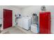 Functional laundry area with washer, dryer, red door, and vintage refrigerator at 2008 Pellam Blvd, Port Charlotte, FL 33948