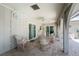 Covered patio features brick floors, ceiling fan, outdoor furniture, and arched columns overlooking the screened-in pool at 2008 Pellam Blvd, Port Charlotte, FL 33948