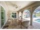 Covered patio features brick floors, ceiling fan, outdoor furniture, and arched columns overlooking the screened-in pool at 2008 Pellam Blvd, Port Charlotte, FL 33948