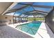 Screened-in pool area features a beautiful pool, brick floors, and ample space for outdoor relaxation and entertaining at 2008 Pellam Blvd, Port Charlotte, FL 33948