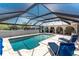 Screened-in pool area features a beautiful pool, brick floors, and ample space for outdoor relaxation and entertaining at 2008 Pellam Blvd, Port Charlotte, FL 33948