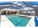 Screened-in pool area features a beautiful pool, brick floors, and ample space for outdoor relaxation and entertaining at 2008 Pellam Blvd, Port Charlotte, FL 33948