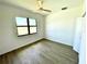Cozy bedroom with a ceiling fan, natural light, and hardwood flooring at 23120 Newcun Ave, Punta Gorda, FL 33980