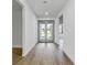 Entrance hall showcasing light wood flooring, leading to the open living area through glass double doors at 23120 Newcun Ave, Punta Gorda, FL 33980