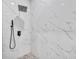 Contemporary shower with marble-style tile and a rainfall showerhead at 23120 Newcun Ave, Punta Gorda, FL 33980