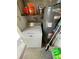 A well-lit utility area with a washing machine, water heater, and storage shelf at 2328 Picnic St, Port Charlotte, FL 33952