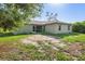 An expansive backyard view of the home featuring a screen porch and large green trees at 2381 Sheila Ln, North Port, FL 34286