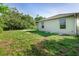 Exterior backyard view with a large grassy area surrounding the home at 2381 Sheila Ln, North Port, FL 34286