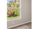 Bedroom with neutral paint, hardwood flooring, and a backyard view through a white window at 2381 Sheila Ln, North Port, FL 34286