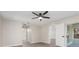 Open bedroom featuring modern fan, wood-look floors, access to bathroom and sliding glass doors at 2381 Sheila Ln, North Port, FL 34286