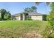 Inviting single-story home with lush lawn, well manicured landscaping, and attached two-car garage at 2381 Sheila Ln, North Port, FL 34286