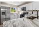 Modern kitchen features stainless steel appliances, granite countertops and bright white cabinets at 2381 Sheila Ln, North Port, FL 34286