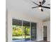 Bright living room featuring modern ceiling fan, neutral walls, vaulted ceiling, and sliding glass door to patio at 2381 Sheila Ln, North Port, FL 34286