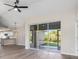 Open-concept living space with ceiling fan, wood floors, slider doors to screened porch, and adjacent kitchen at 2381 Sheila Ln, North Port, FL 34286