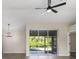 Bright living room featuring modern ceiling fan, wood floors, neutral walls, and sliding glass door to patio at 2381 Sheila Ln, North Port, FL 34286