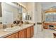 Traditional bathroom with double sinks, wood cabinets, a makeup vanity, and a door to the shower at 24371 Folkstone Ave, Punta Gorda, FL 33980