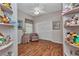 Bedroom with hardwood floors, a ceiling fan, a closet, a chair, and built-in shelving that displays stuffed animals at 24371 Folkstone Ave, Punta Gorda, FL 33980