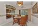 Bright breakfast nook features a round table, four chairs, decorative art, and a large window with backyard views at 24371 Folkstone Ave, Punta Gorda, FL 33980