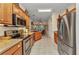 Modern kitchen with stainless steel appliances, granite countertops, and wood cabinets with an open view to the breakfast nook at 24371 Folkstone Ave, Punta Gorda, FL 33980