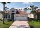 Charming single-story home featuring a well-manicured lawn and a brick driveway leading to a two-car garage at 26089 Seminole Lakes Blvd, Punta Gorda, FL 33955
